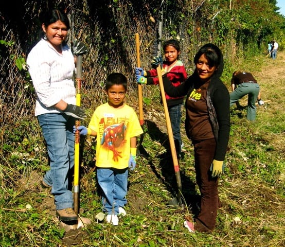Esmeralda Martinez (right) from Trip 1 and her family pause for a photo while digging out invasive blackberry from the grounds of Camp Long.