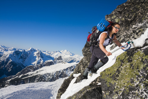 A woman ascends a rocky ridge in the South Picket Range, North Cascades National Park, Washington.